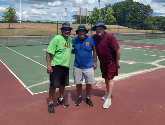 3 men standing on a tennis court